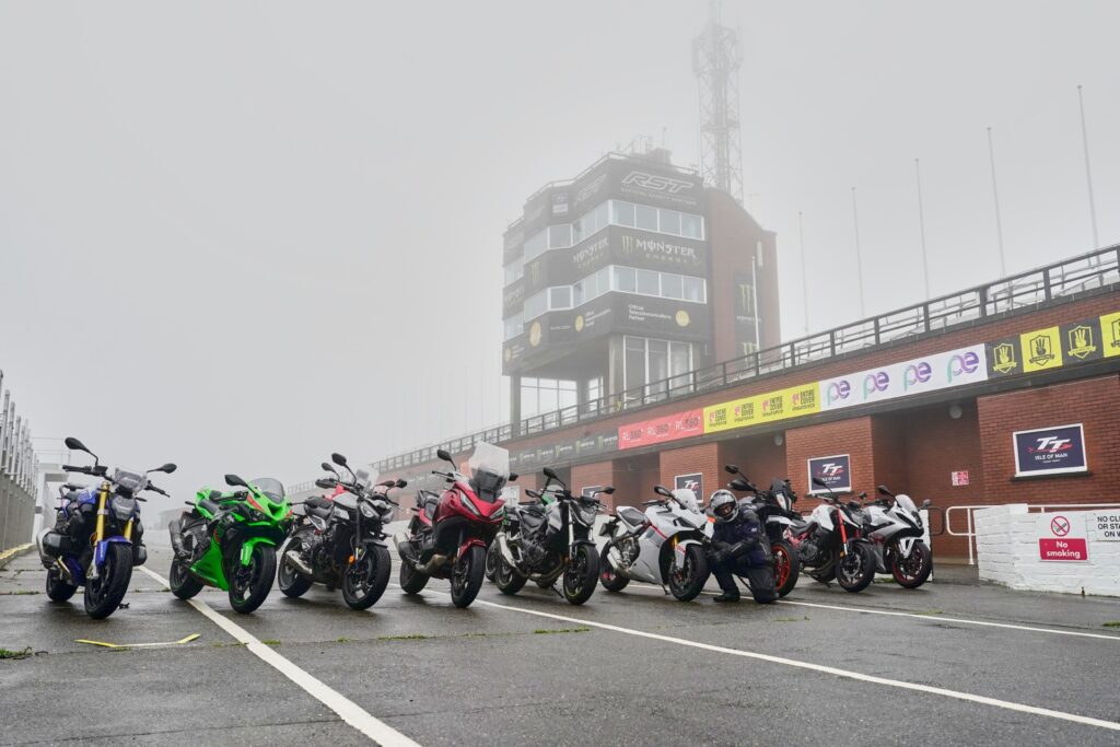 Die Testmaschinen aufgereiht vor der Isle of Man TT grandstand-Tribüne im Start-Zielbereich, bzw. in der Pit-Lane. 