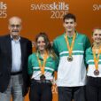 Von links: Bundesrat Guy Parmelin (Vorsteher des Eidgenössischen Departements für Wirtschaft, Bildung und Forschung) mit Nadia Bonard, Gianni Aeberhard und Sara Haab bei der Siegerehrung. © SwissSkills / Manu Friedrich